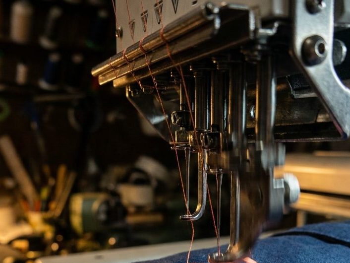 Embroidery machine stitching a coral logo onto a navy garment